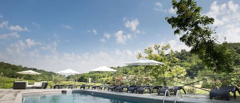 Una piscina al aire libre de temporada, sombrillas