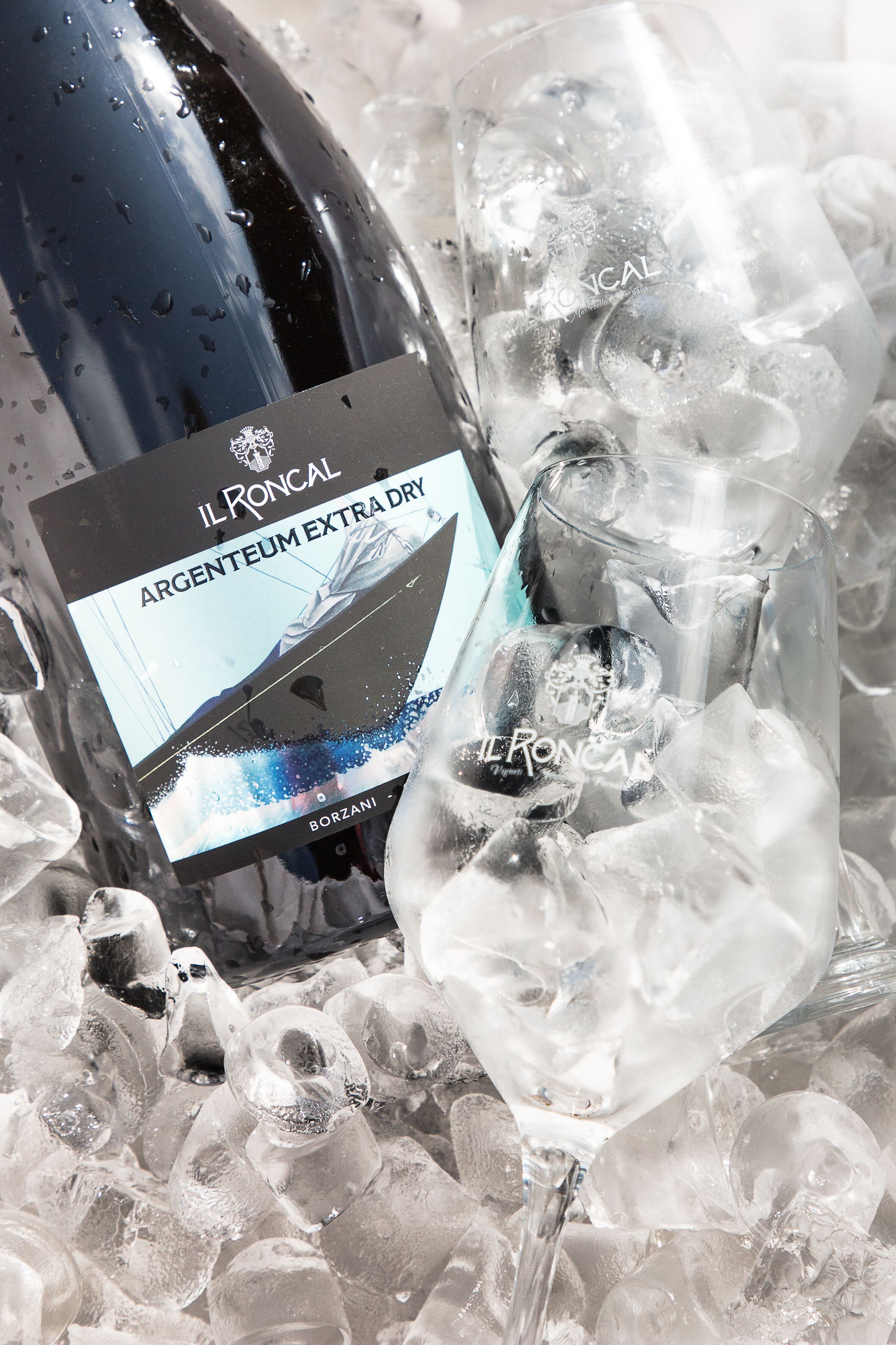 A bottle of Il Roncal Argenteum Extra Dry wine and a glass filled with ice cubes.