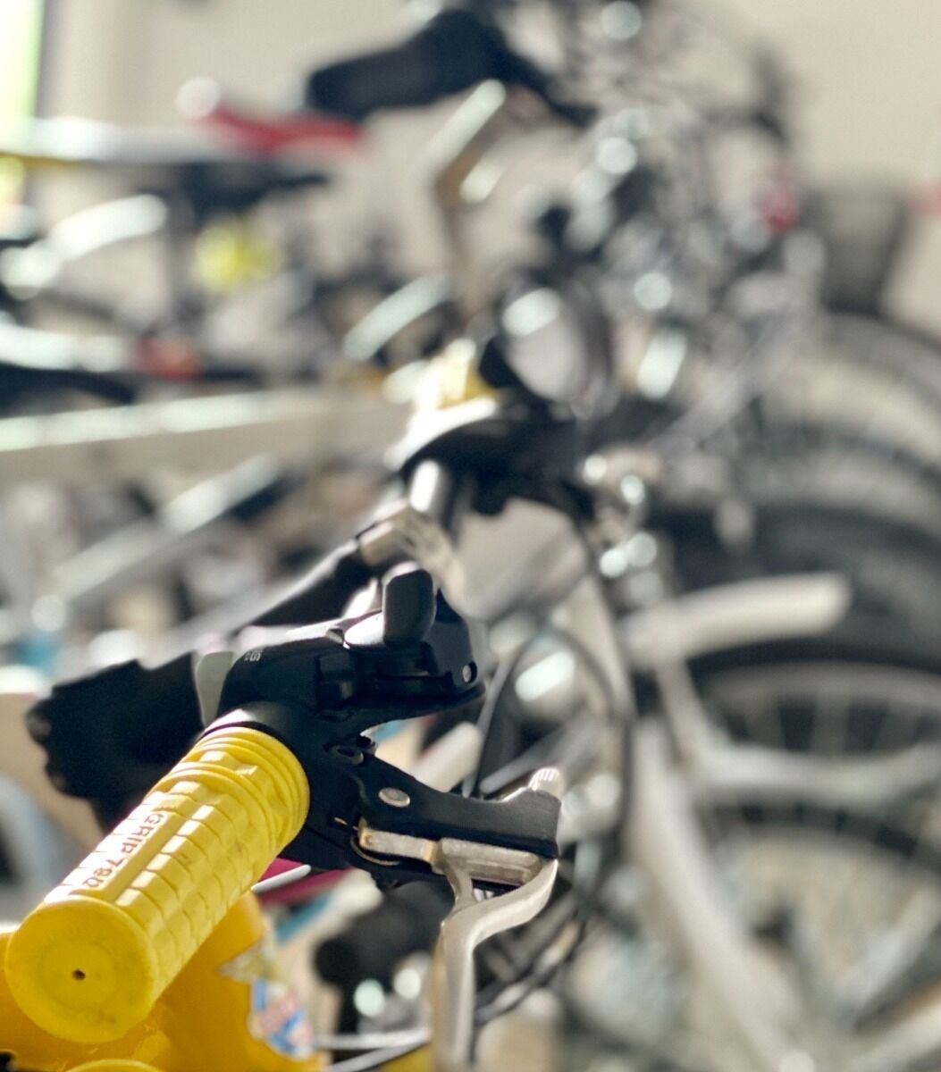 Primer plano del manillar de una bicicleta con una bomba amarilla adherida.