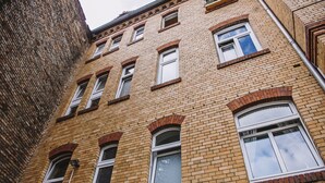 A multi-story brick building with arched windows and a corner entrance. - Pension Bertha (Jena)