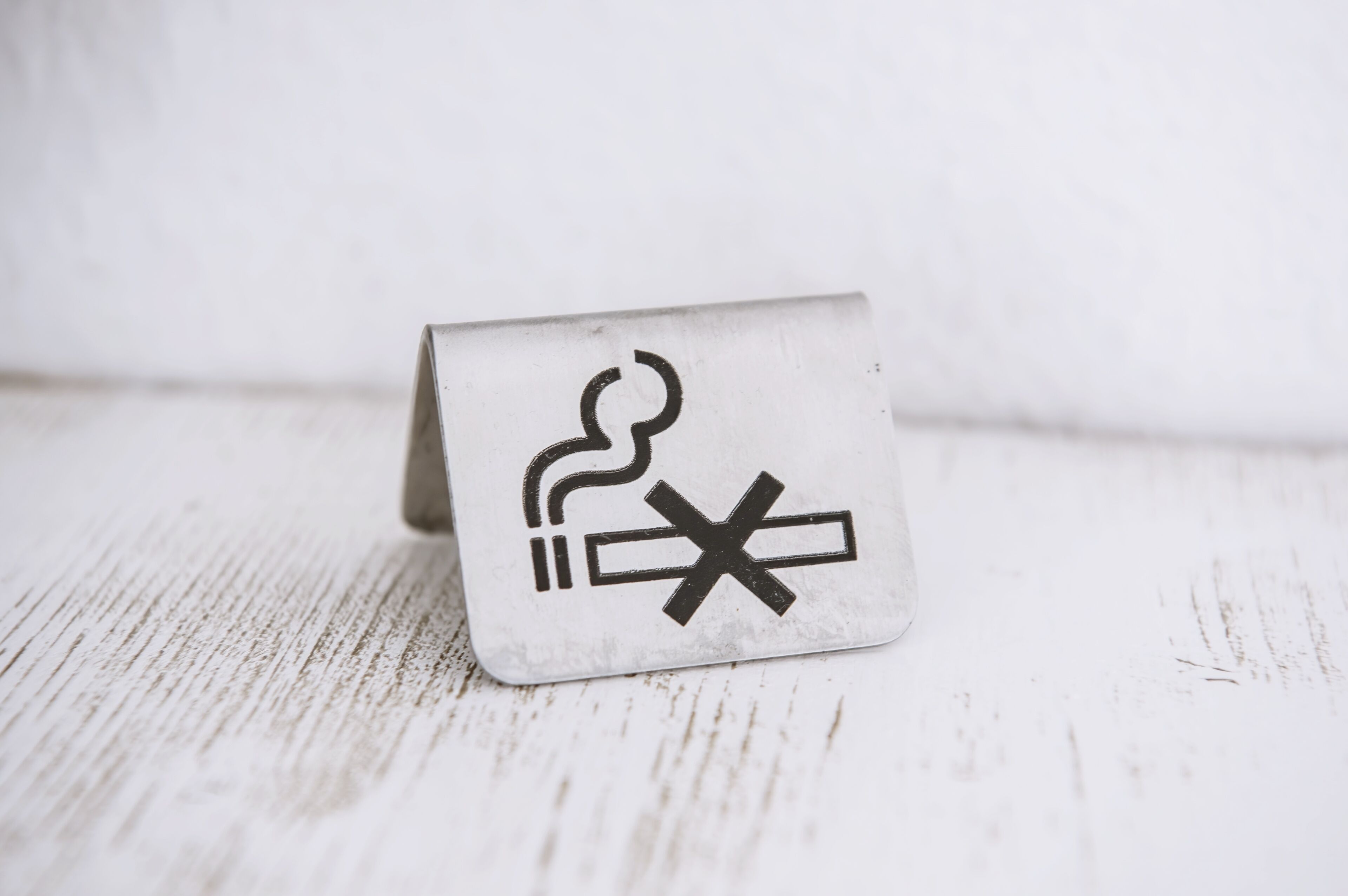 Un objeto cuadrado blanco con un símbolo de humo y un cartel de prohibición.