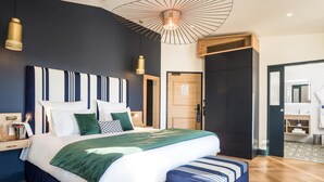 A modern bedroom with a large bed, bedside tables, a bench, and a unique ceiling light fixture.