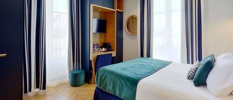 Een hotelkamer met een bed, een bureau en een kledingkast.