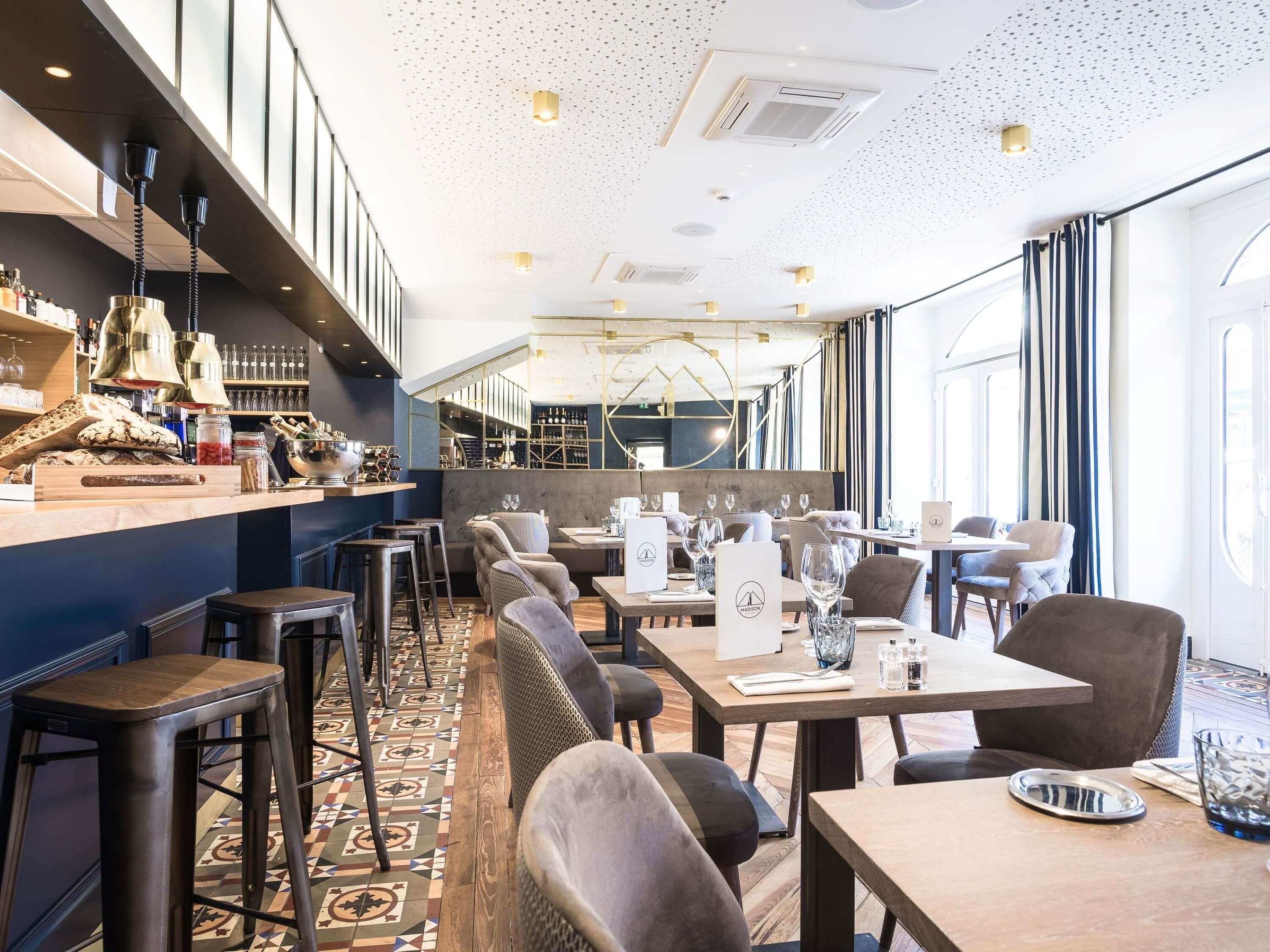 A restaurant with a bar area, seating, and a patterned floor.
