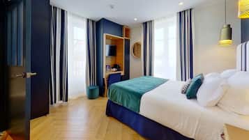 Una habitación de hotel con cama, escritorio, silla, espejo y armario.
