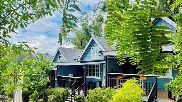 A two-story house with a front porch, a staircase, and a pathway leading to the entrance.