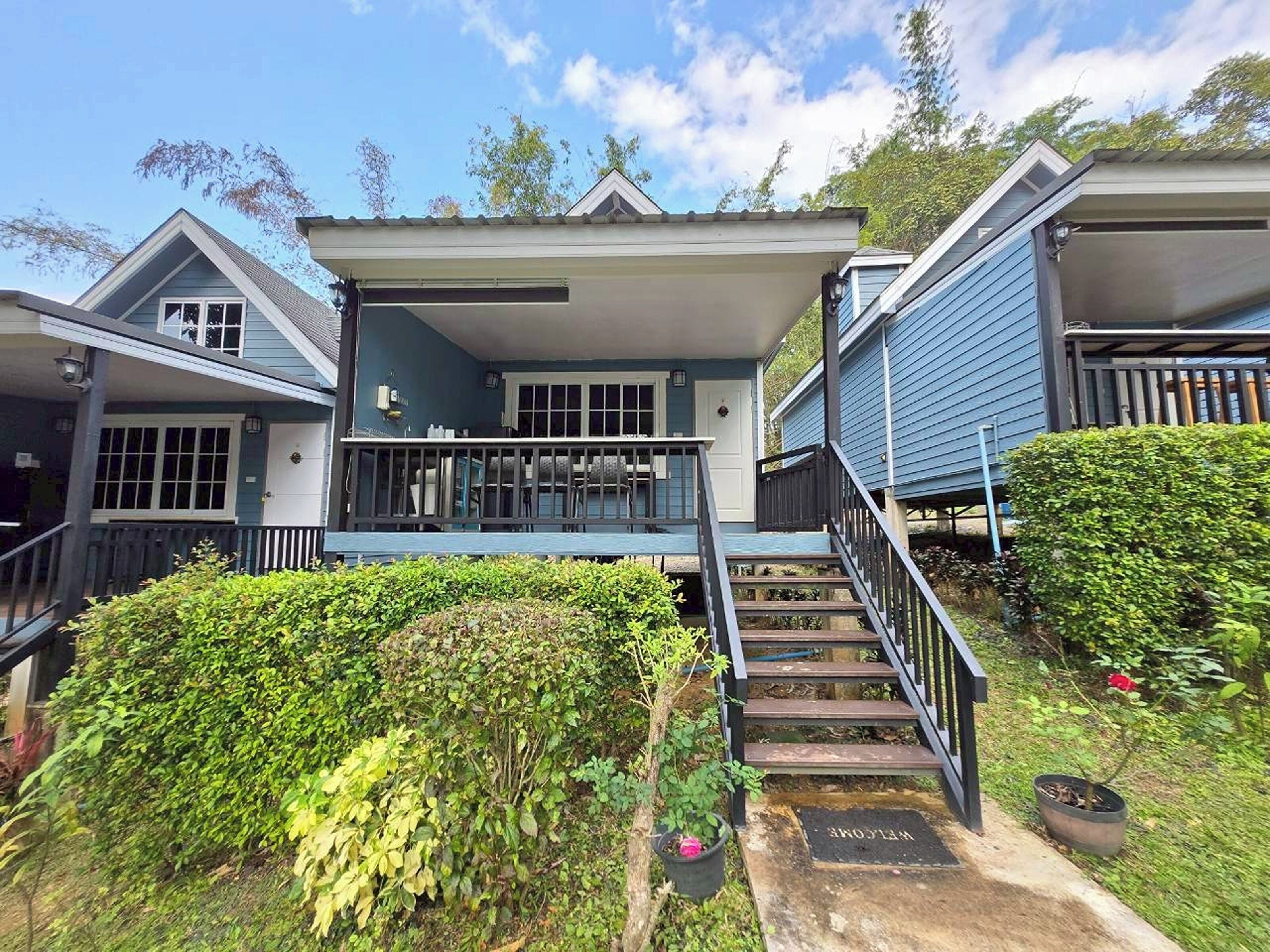 A two-story house with a covered porch and a staircase leading to the entrance.
