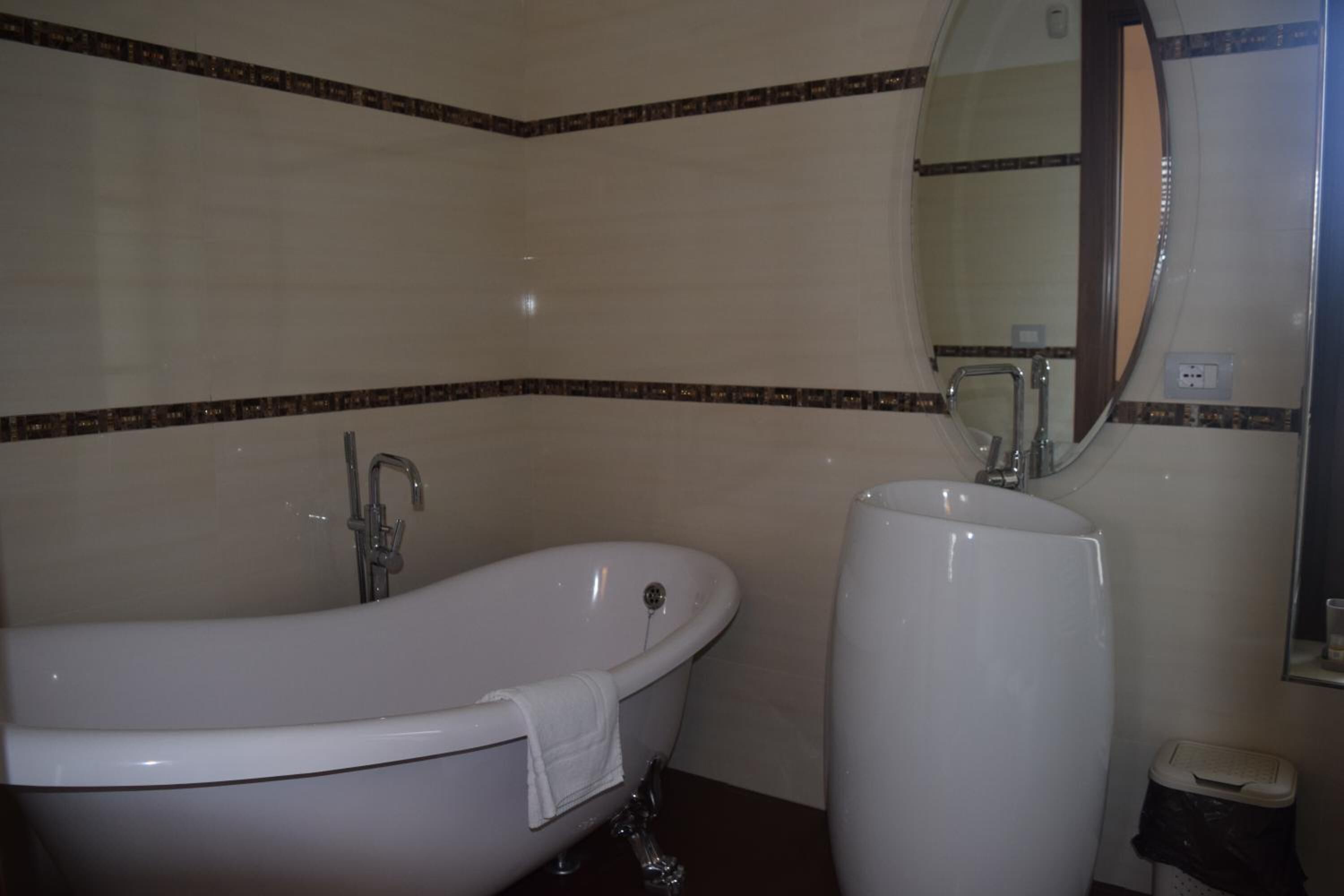 Une salle de bain avec une baignoire sur pieds, un lavabo et un miroir.