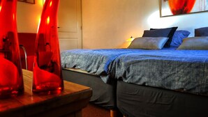 A bedroom with two beds, a wooden table, and red chairs. - B&B Zandhuizen (Zandhuizen)
