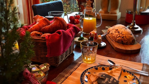 A cozy breakfast setting with croissants, orange juice, and a plate with a 'Happy New Year' message. - B&B Zandhuizen (Zandhuizen)