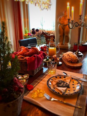 A cozy breakfast setting with croissants, orange juice, and a plate with a 'Happy New Year' message. - B&B Zandhuizen (Zandhuizen)