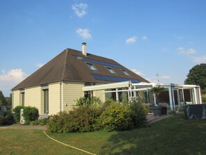 A house with a sloped roof, a conservatory, and a garden. - Maison Magdala (Fourmies)