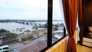 Quarto com vista para um rio e uma ponte.