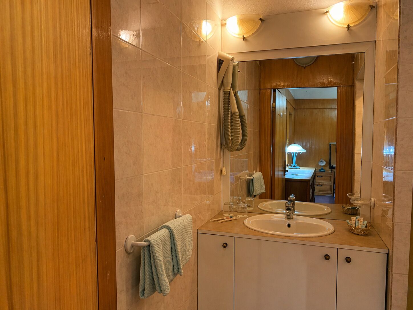 A bathroom with two sinks, a mirror, and a towel rack.