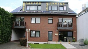 Ein zweistöckiges Backsteingebäude mit der Aufschrift "HAGARTEN HOTEL" auf dem Dach.