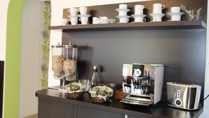 Ein Kaffeeangebot mit Kaffeemaschine, Tassen und Toaster.