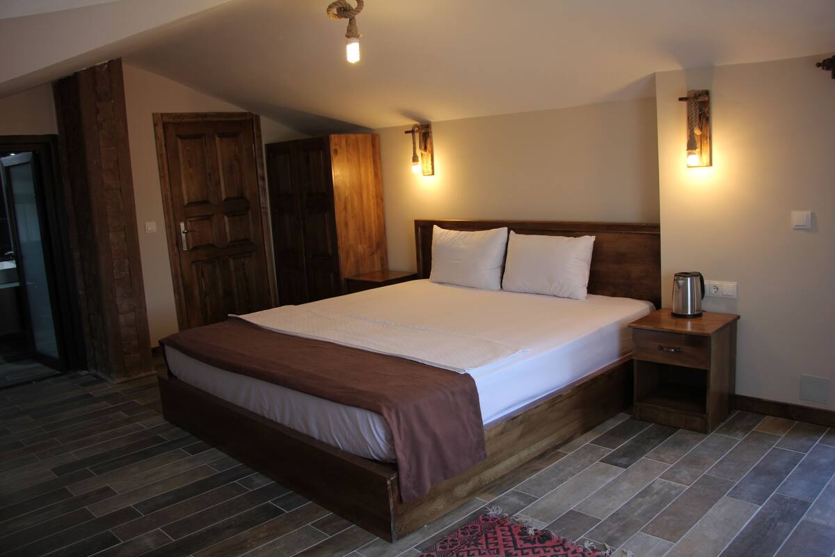 A bedroom with a large bed, wooden headboard, bedside tables, and a built-in wardrobe.