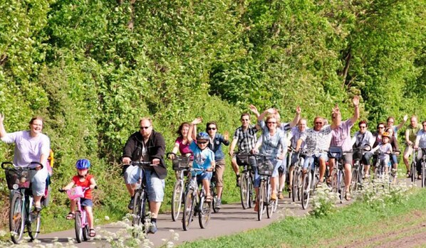 A group of people riding bicycles on a paved path surrounded by greenery. - Hotel Mutter Bahr (Ibbenbueren)