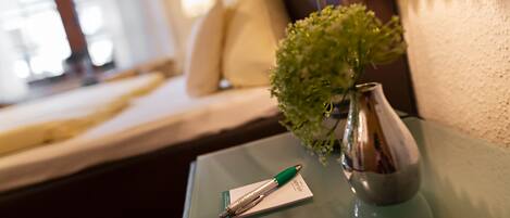 A glass table with a pen, a small plant, and a lamp.