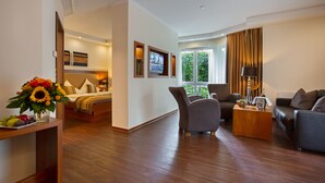 Una habitación de hotel moderna con cama, sofá, mesita de café y televisión.