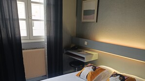 Une chambre à coucher avec un lit, un bureau et un radiateur.