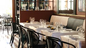 A restaurant with checkered flooring, black chairs, and tables set with wine glasses and plates. - Cocorico Luxury House - Porto (Porto)