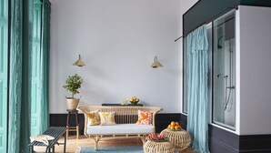 A room with a wicker sofa, a small table, a bench, a potted plant, and wicker baskets. - Cocorico Luxury House - Porto (Porto)