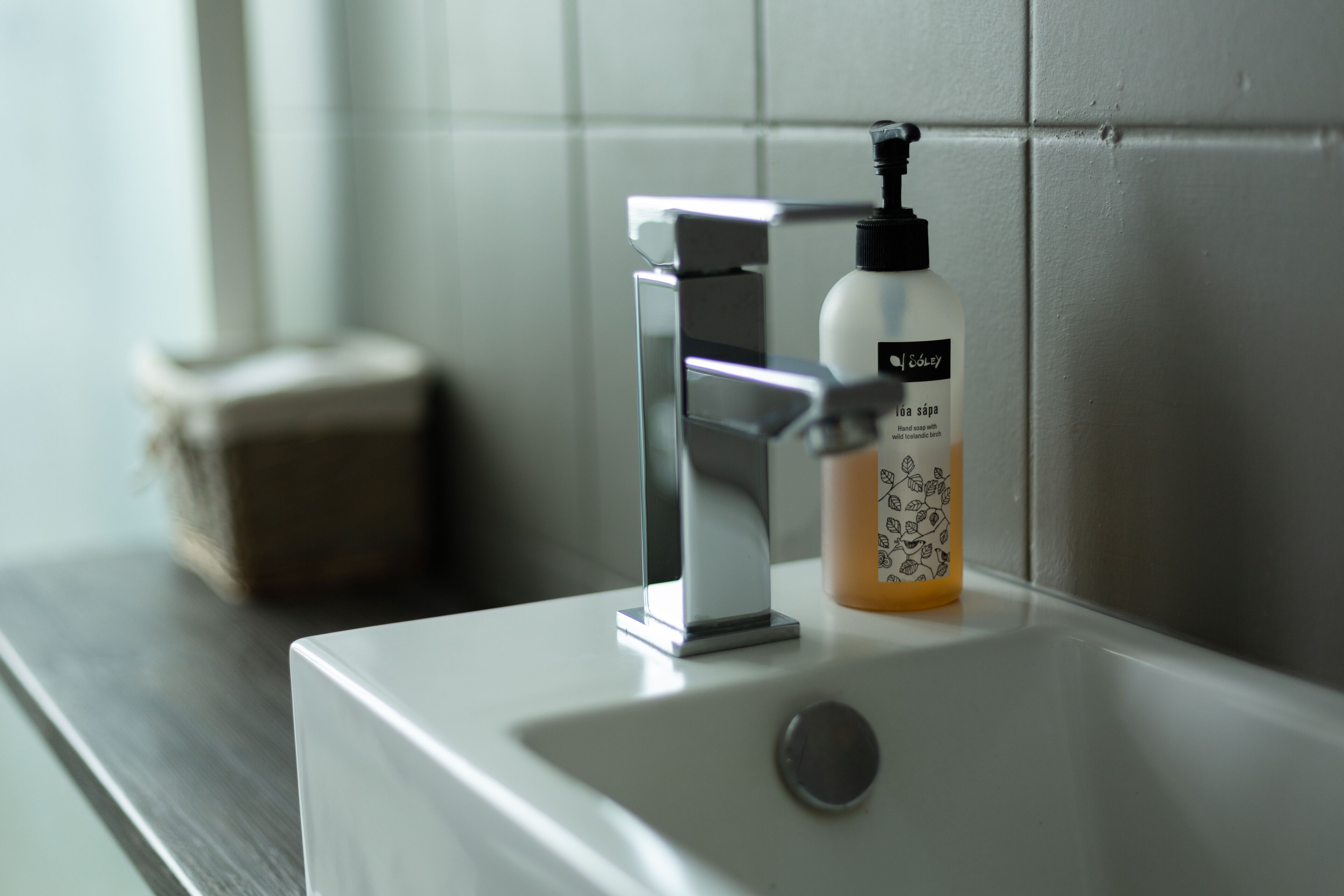 A bathroom sink with a modern faucet and a soap dispenser.