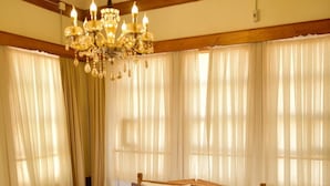 A bedroom with a large bed, wooden headboard, a chandelier, and curtains. - Cifte Konak Butik Otel (Amasya)