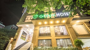 A hotel with a green sign, a staircase, and a well-lit entrance. - Green Hadong Hotel (Hanoi)