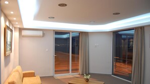 Una sala de estar moderna con un sofá, una mesa de centro y puertas correderas de vidrio que dan a un balcón.