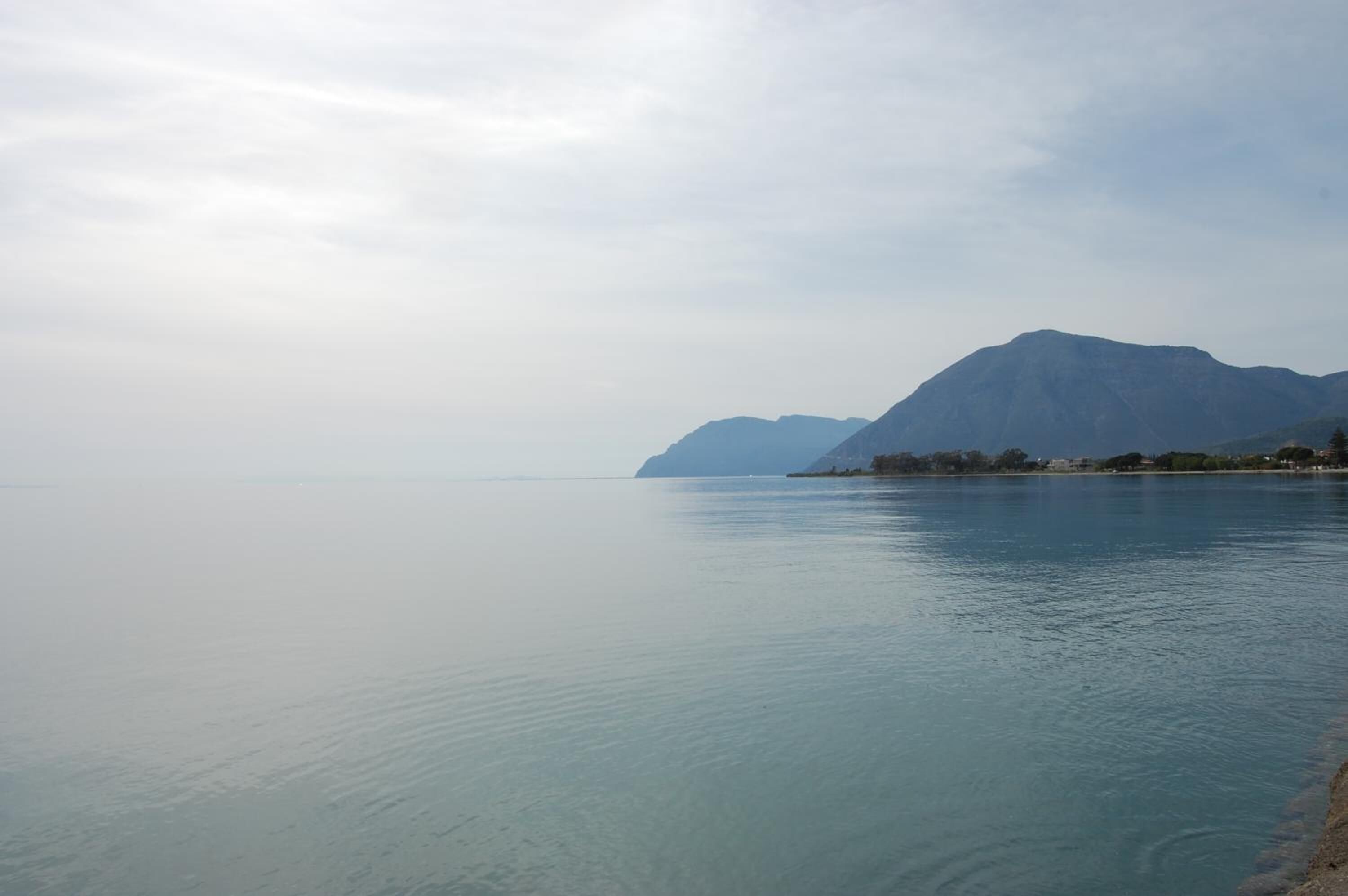 A calm lake with mountains in the background.