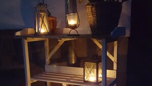 A wooden outdoor shelf with two lit lanterns and a potted plant. - BellaCaro (Loehne)