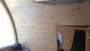 Cocina compacta con fregadero, estufa y armarios de madera.