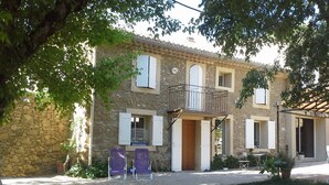 Un edificio de piedra con balcón, puerta y ventana.