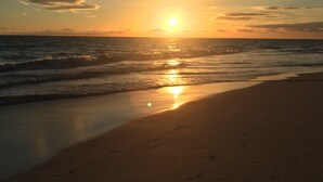 A beach with the sun setting over the ocean, creating a calm and serene atmosphere. - Hotel Capriccio Mare y Restaurante (Punta Cana)