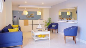 A modern living room with a sofa, armchairs, a coffee table, and a wall-mounted shelf. - Hotel Capriccio Mare y Restaurante (Punta Cana)