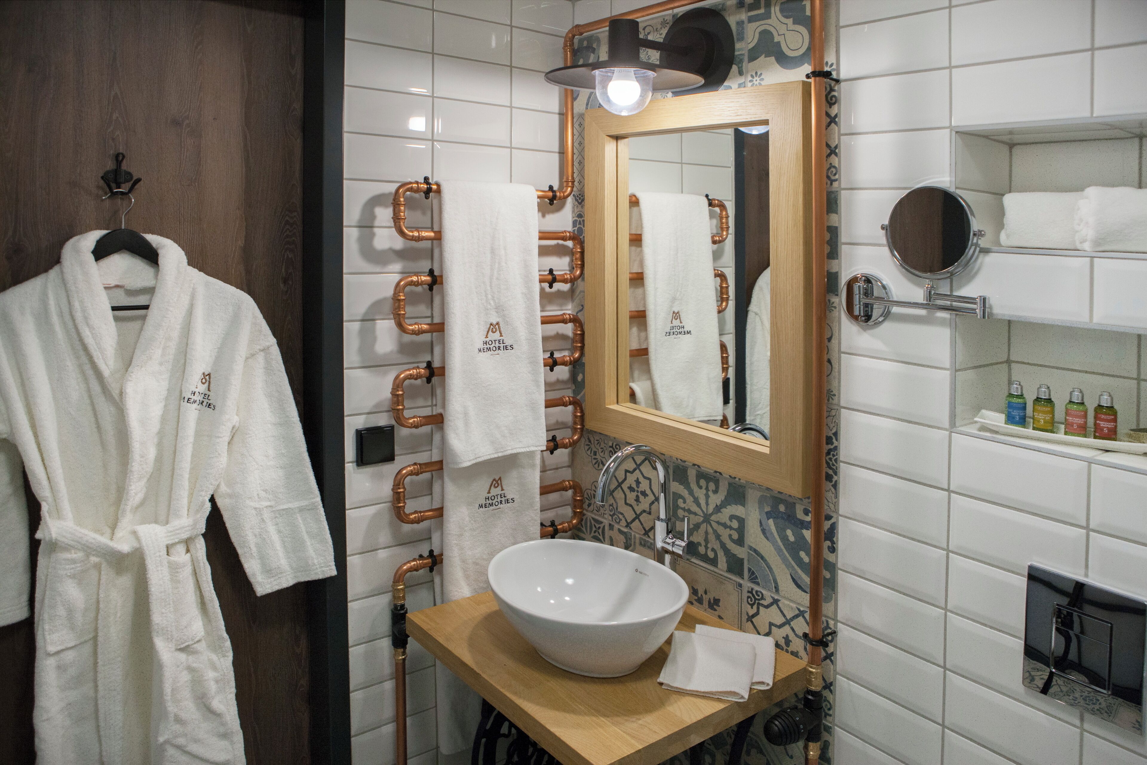 Un baño con un espejo grande, un lavamanos y un perchero para toallas.