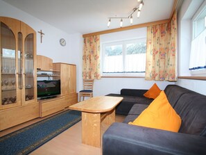 Relax in this inviting living room with a sofa, coffee table, and television.