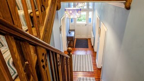 Una escalera de madera con un tapete estampado que lleva a una puerta.
