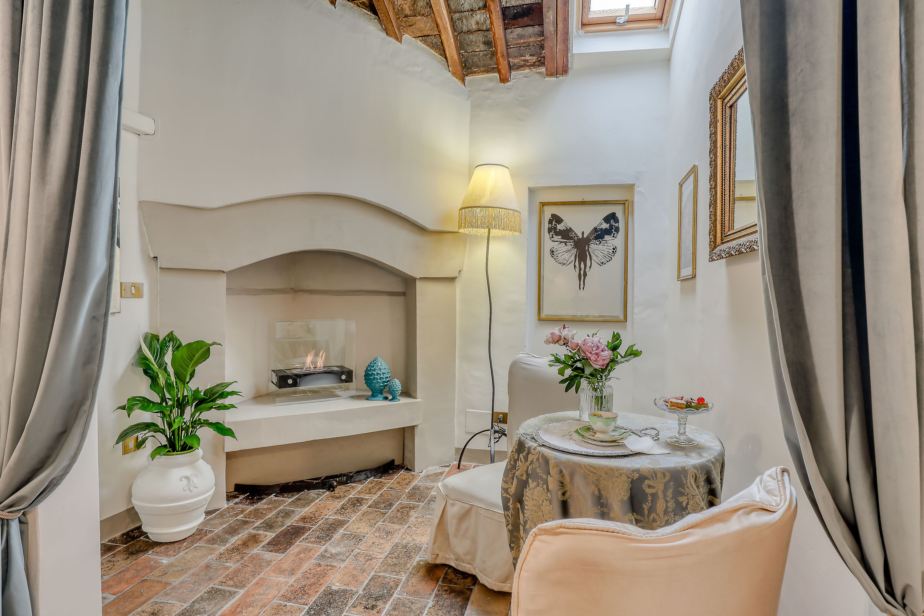 Una habitación acogedora con chimenea, una mesa adornada con flores y una silla.