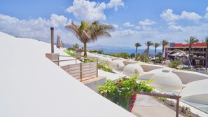 Ein Resort mit weißkuppeligen Strukturen, einer Treppe und Blick auf das Meer.