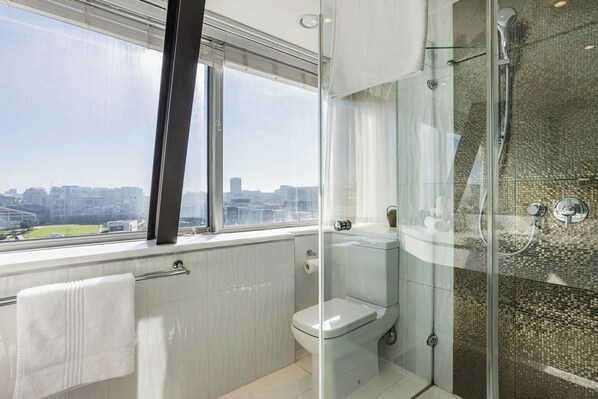 Un baño moderno con cabina de ducha de vidrio, inodoro y barra para toallas.