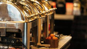 Un buffet avec une machine à café et un récipient rempli de tomates.