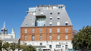 A hotel with a modern design, featuring a prominent rooftop terrace and a brick facade.
