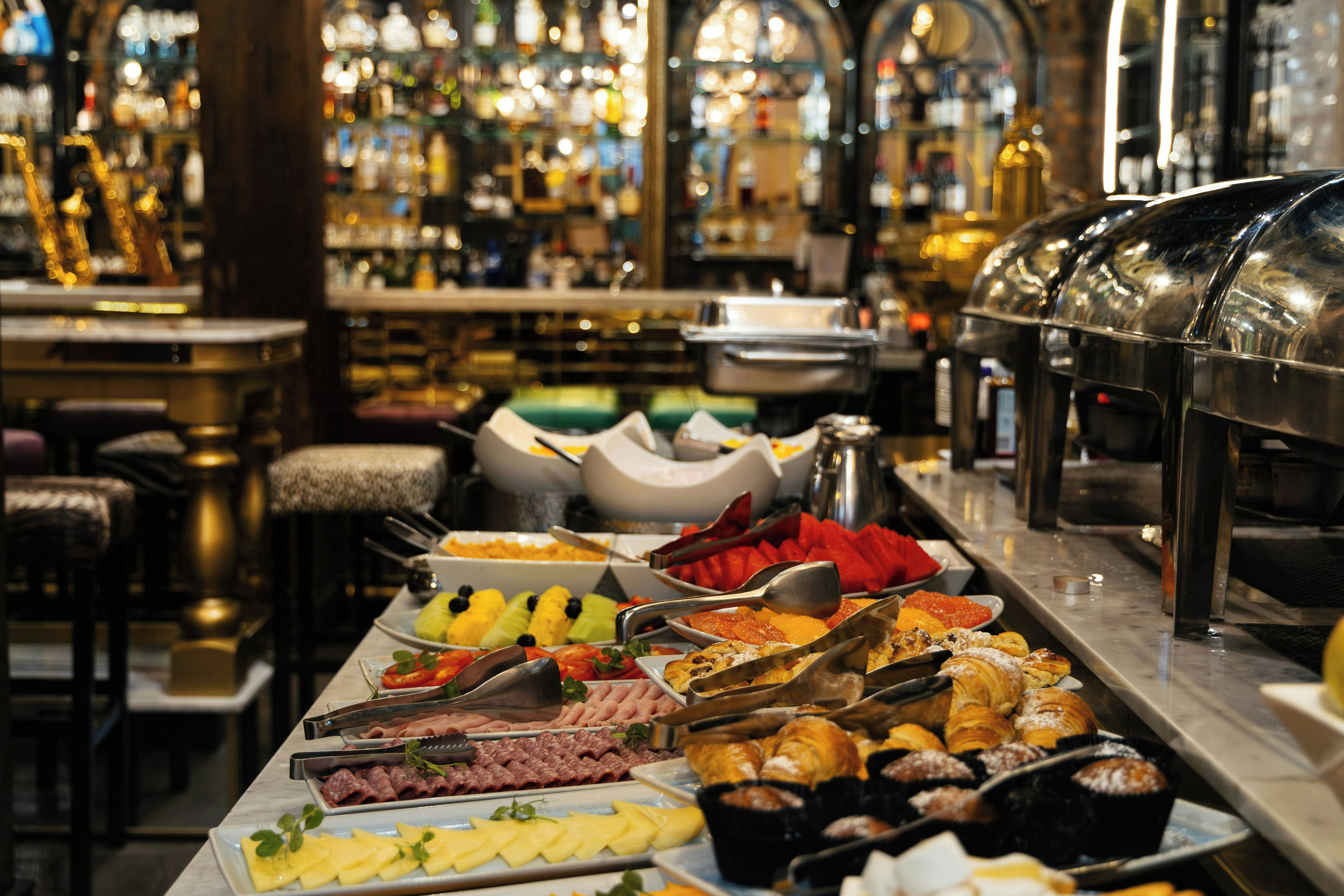 Un bufé con diferentes opciones de comida y un área de bar al fondo.