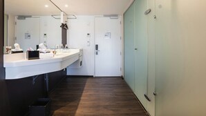 Un baño moderno con un espejo grande, dos lavamanos y una zona de ducha.