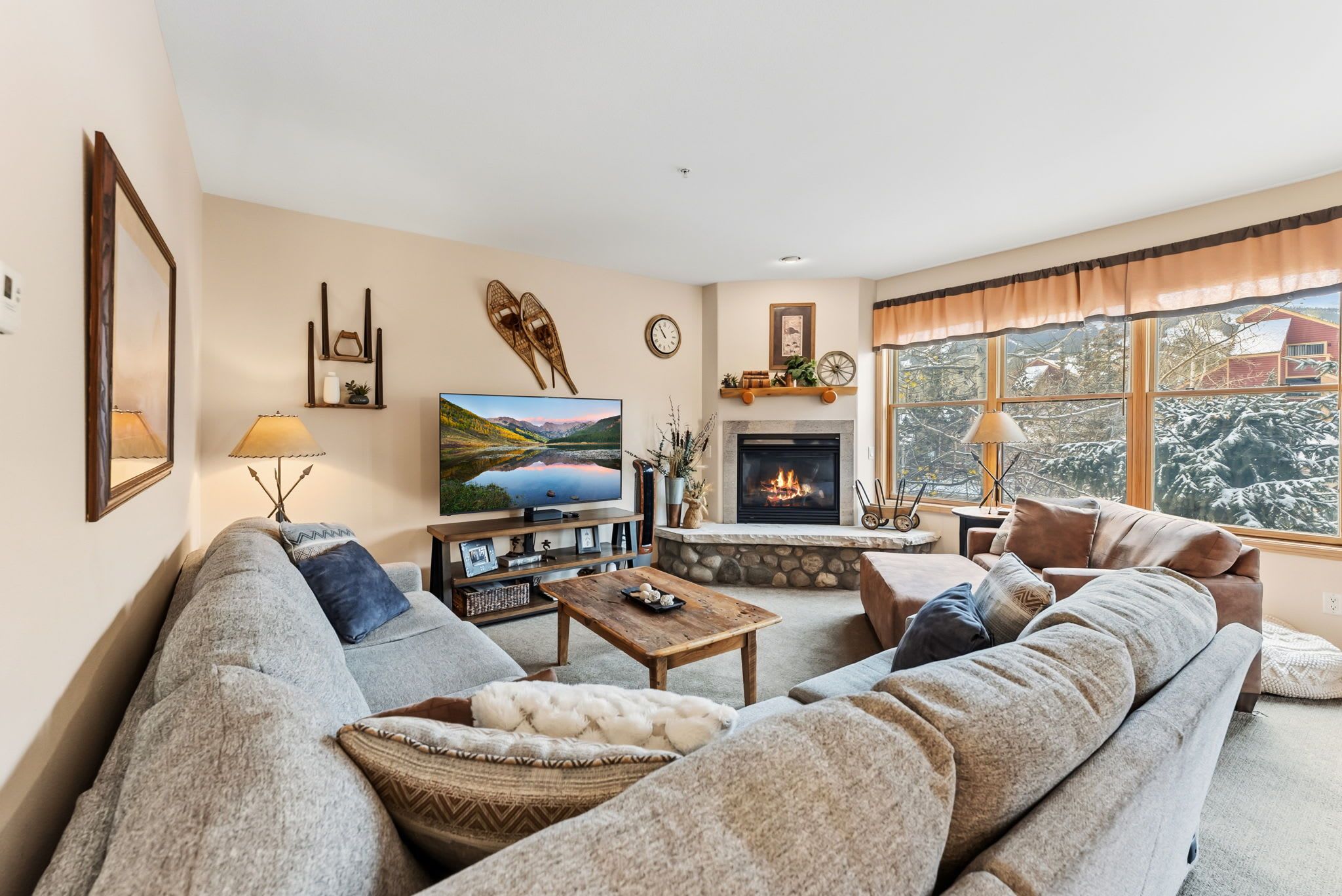 A cozy living room with a fireplace, a large TV, and comfortable seating.
