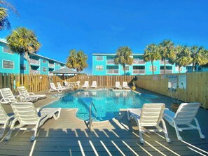 A pool area with lounge chairs and a wooden deck. - Lani Kai Village 211, Beautifully Remodeled Condo with Indirect Gulf Views! (Gulf Shores)