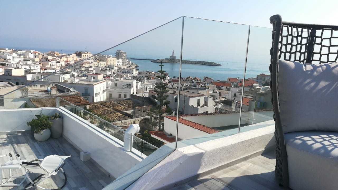 A rooftop terrace with a clear view of a coastal cityscape, including a lighthouse.